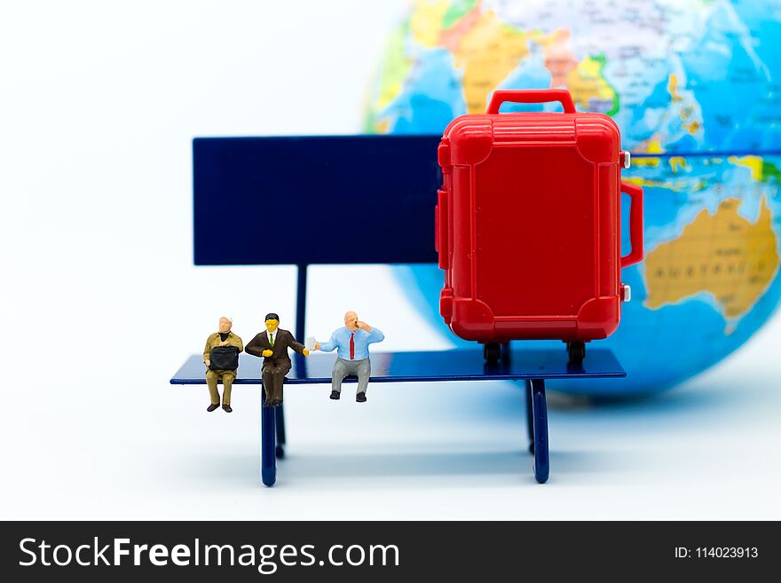 Miniature people : Businessman sitting on chair and have a red suitcase, world map for background. Image use for travel, business concept.