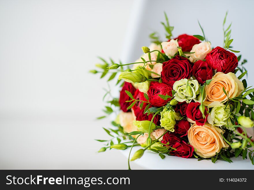 Bridal bouquet with red and yellow roses, with a red satin ribbon on a white background. Bridal bouquet with red and yellow roses, with a red satin ribbon on a white background