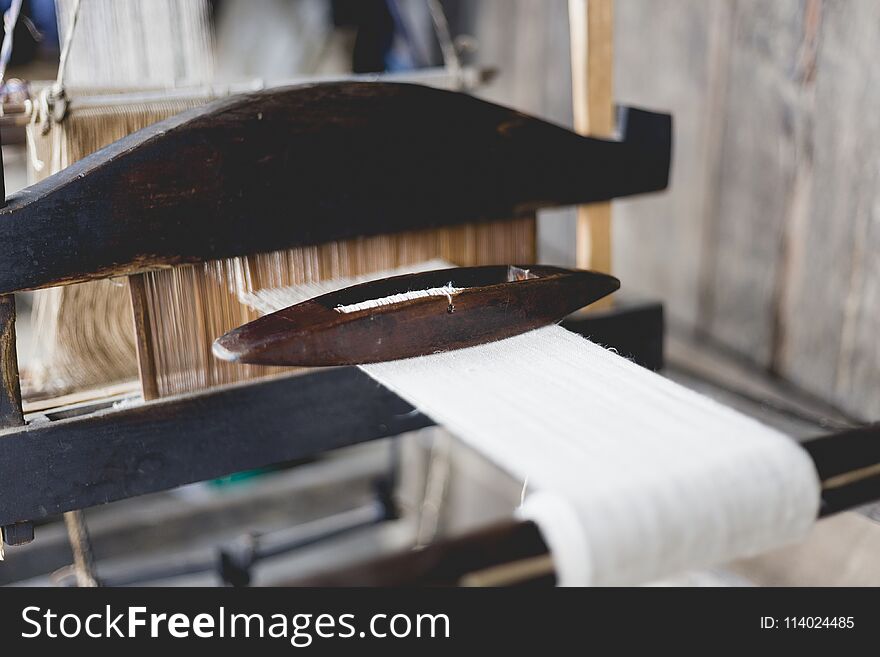 Weaving and manufacturing of handmade carpets closeup. Use for weaving traditional Thai silk. Production in Thailand.