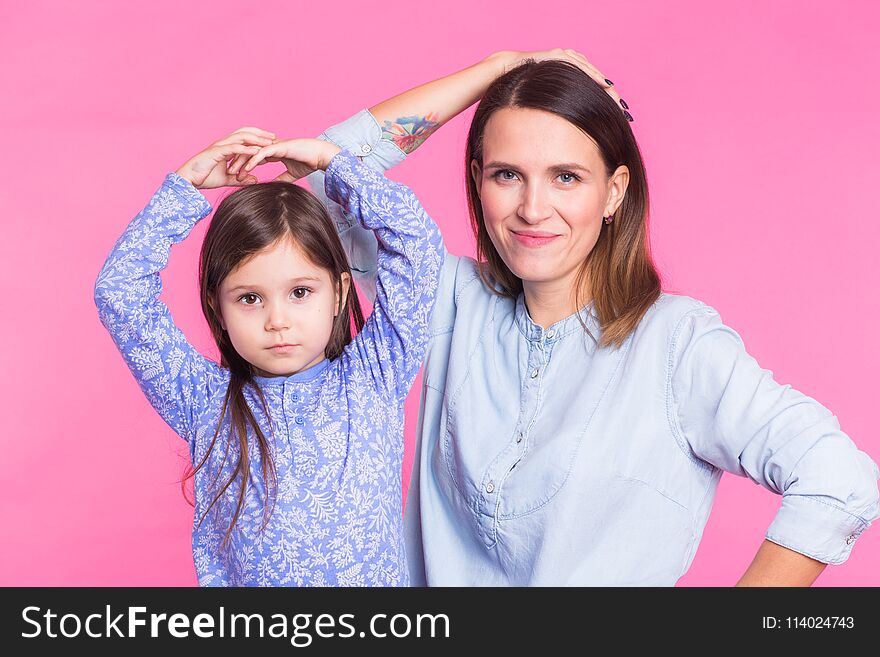 Funny woman and kid over pink background. Happy family playing in home