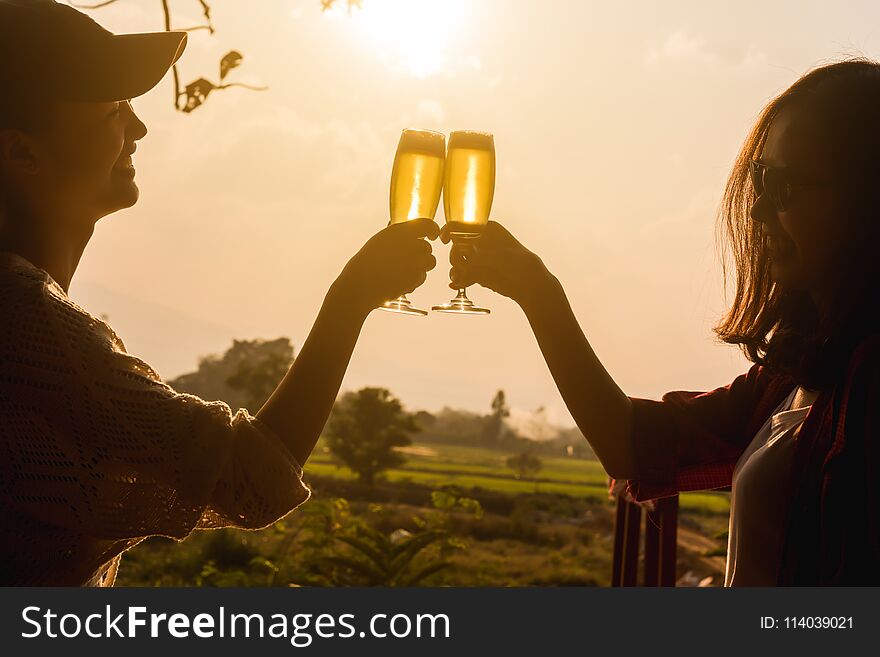 Hands of two women toast champange celebrating under afternoon sunlight, celebrating occation