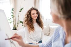 A Senior Woman Painting A Teenage Girl At Home. Stock Images