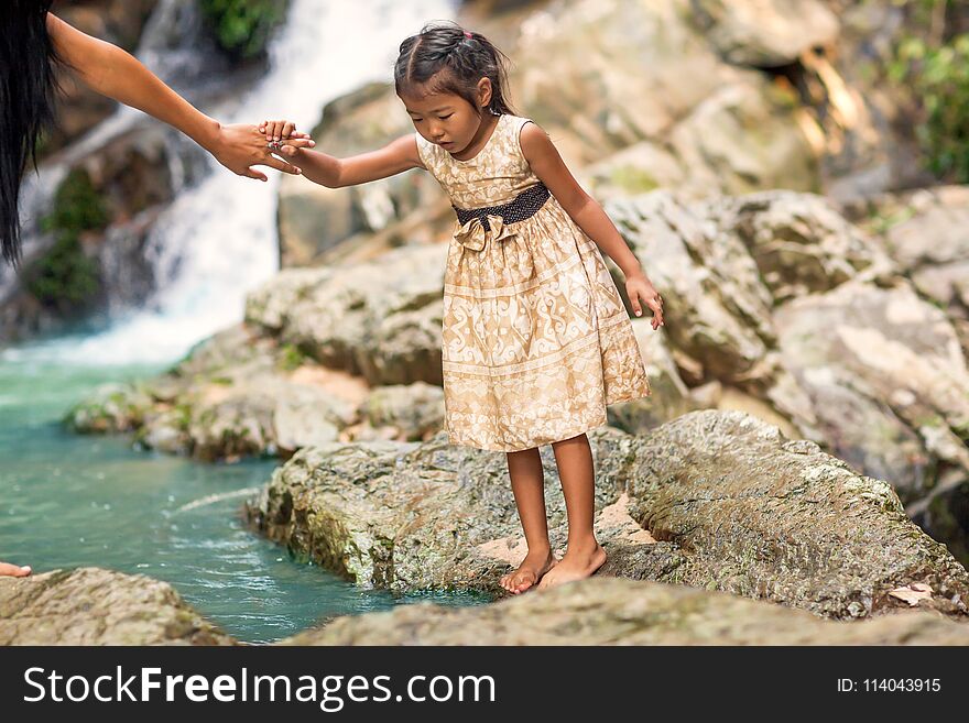 Happy Mother With Her Daughter In The Tropics Near The Waterfall