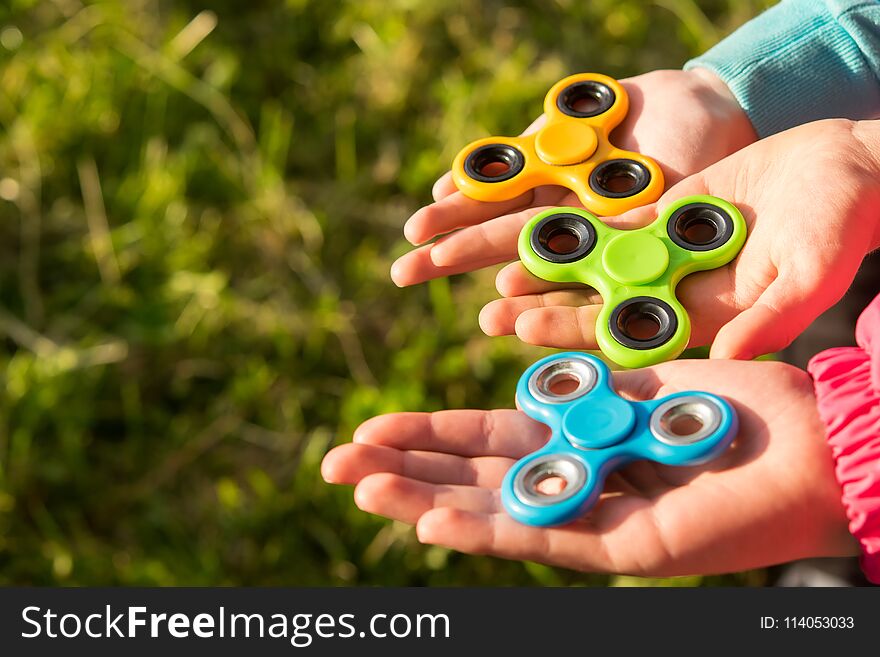 Three Childrens Hands Hold The Spinners Together