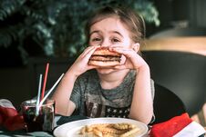 Little Girl In Cafe With Burger Royalty Free Stock Photo