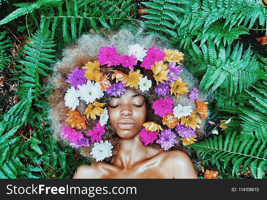 Woman With Floral Headdress Lying on Green Leaf Plants