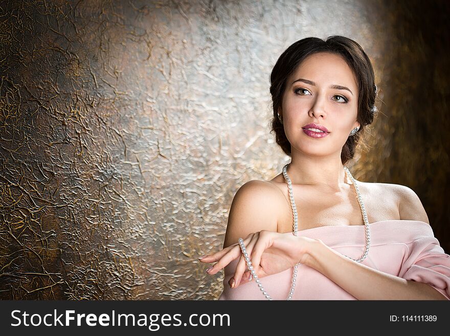 Young elegant woman in evening gold dress