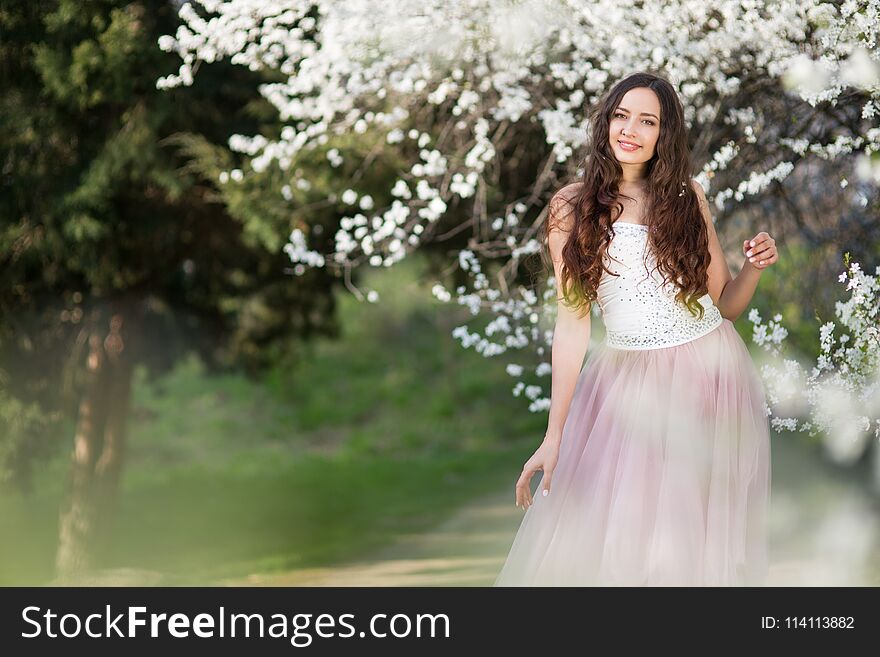 Young long-haired woman in the garden blooming in spring. Young long-haired woman in the garden blooming in spring