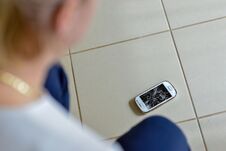 Woman Picking Broken Smart Phone With Cracked Screen Of The Tile Royalty Free Stock Photography Woman Picking Broken Smart Phone With Cracked Screen Of The Tile Royalty Free Stock Photography