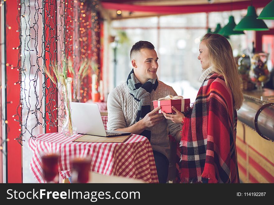 Smiling couple with a gift on a date indoors