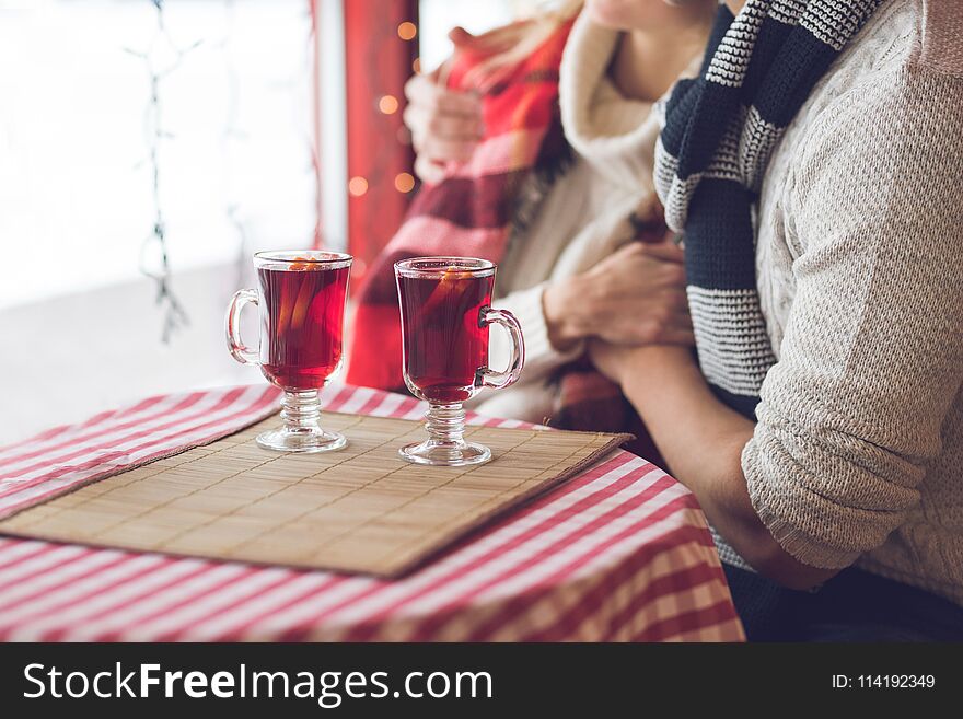 Young couple with glasses of mulled wine in a restaurant