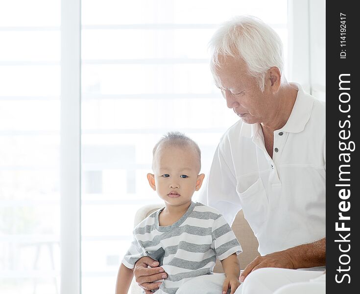 Portrait of Asian grandfather and grandchild at home, family indoor lifestyle. Portrait of Asian grandfather and grandchild at home, family indoor lifestyle.