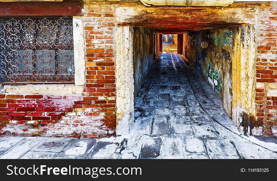 Narrow passage between old houses in Venice. Street with archway in the medieval italian town. Narrow passage between old houses in Venice. Street with archway in the medieval italian town.