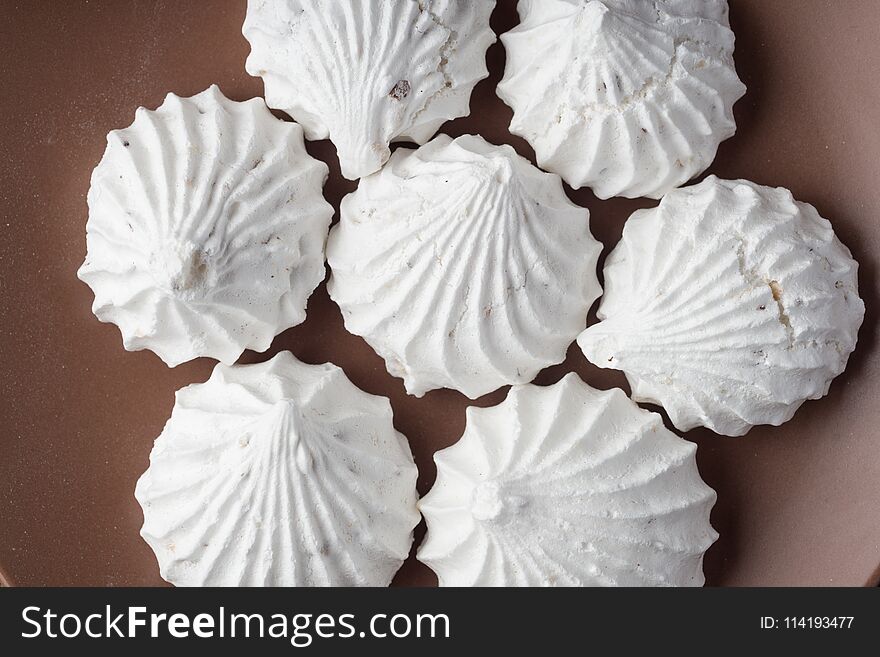 Sweet dessert white zephyr marshmallows on clay plate and rustic wooden background. Sweet dessert white zephyr marshmallows on clay plate and rustic wooden background