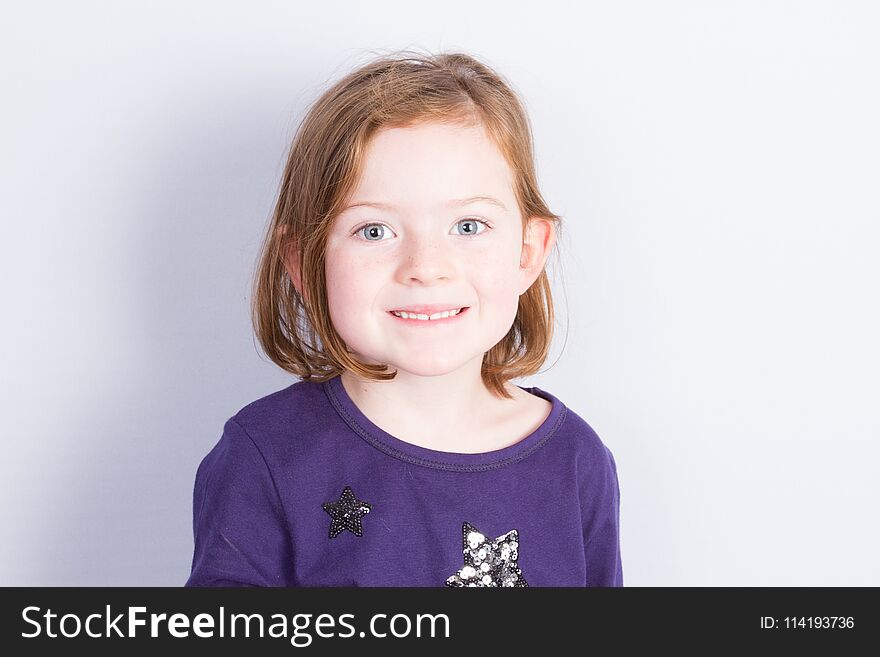 Portrait Of Girl Sitting Under Wall Isolated In Grey White