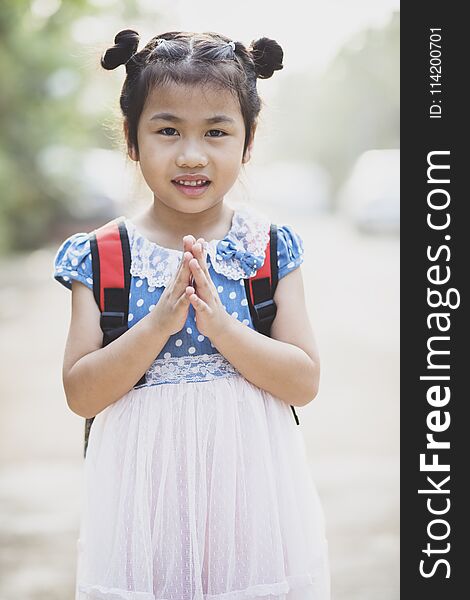 Thai children posting sawasdee acting toothy smiling face outdoor