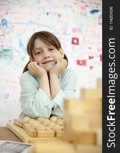 Cute schoolgirl playing with wooden puzzles. Cute schoolgirl playing with wooden puzzles.