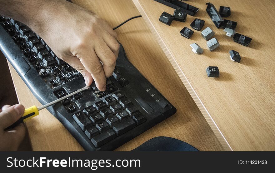 Close-up of male hands cleaning a dirty keyboard. Close-up of male hands cleaning a dirty keyboard