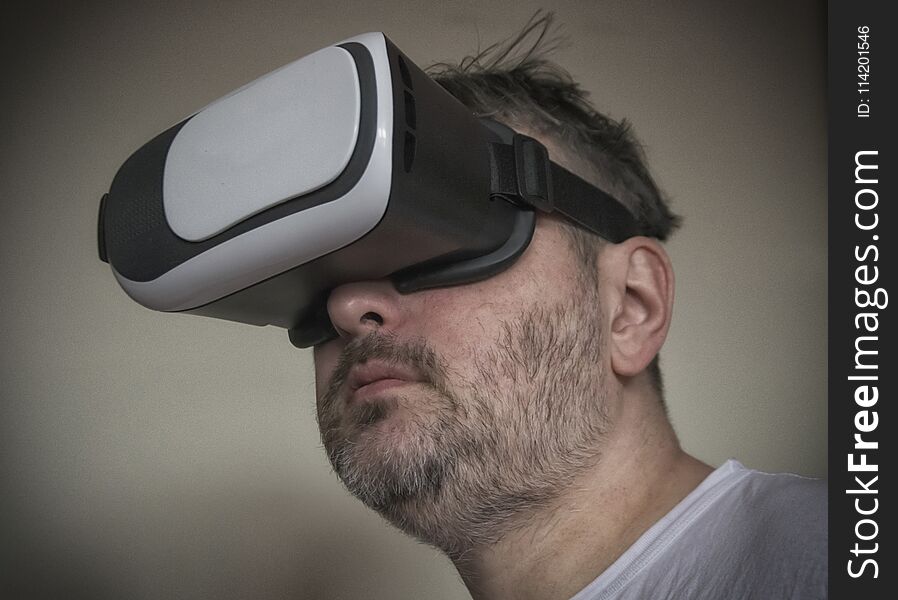 A close-up of a middle-aged man with a virtual reality headset. A close-up of a middle-aged man with a virtual reality headset