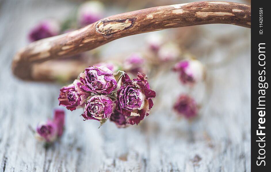 Vintage background with dry tea roses on the wood