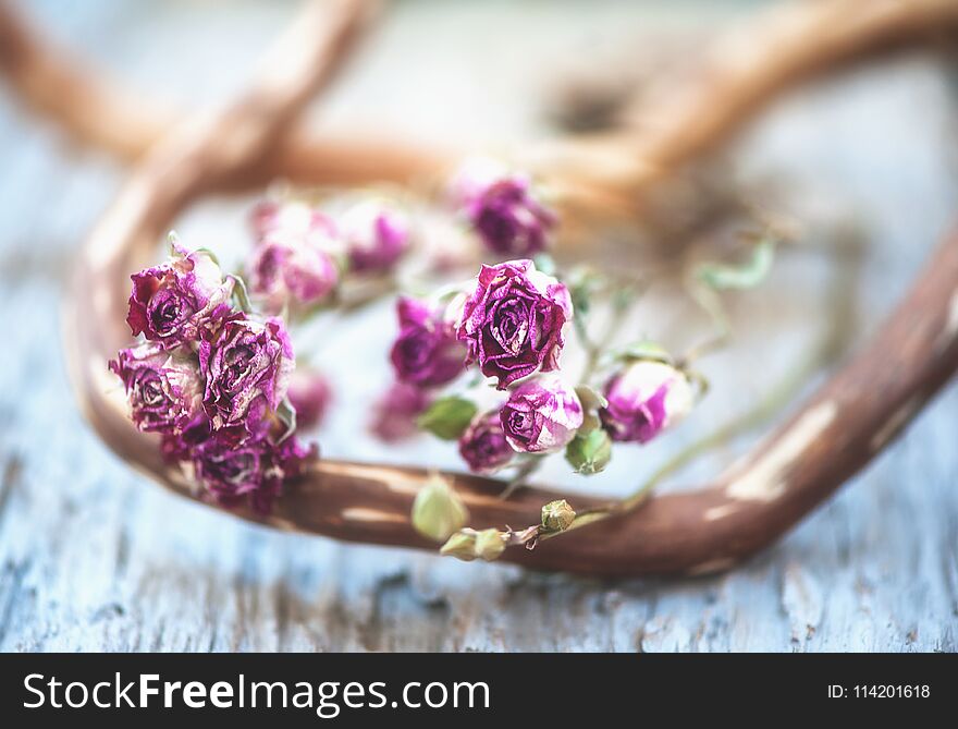 Vintage background with dry tea roses on the wood