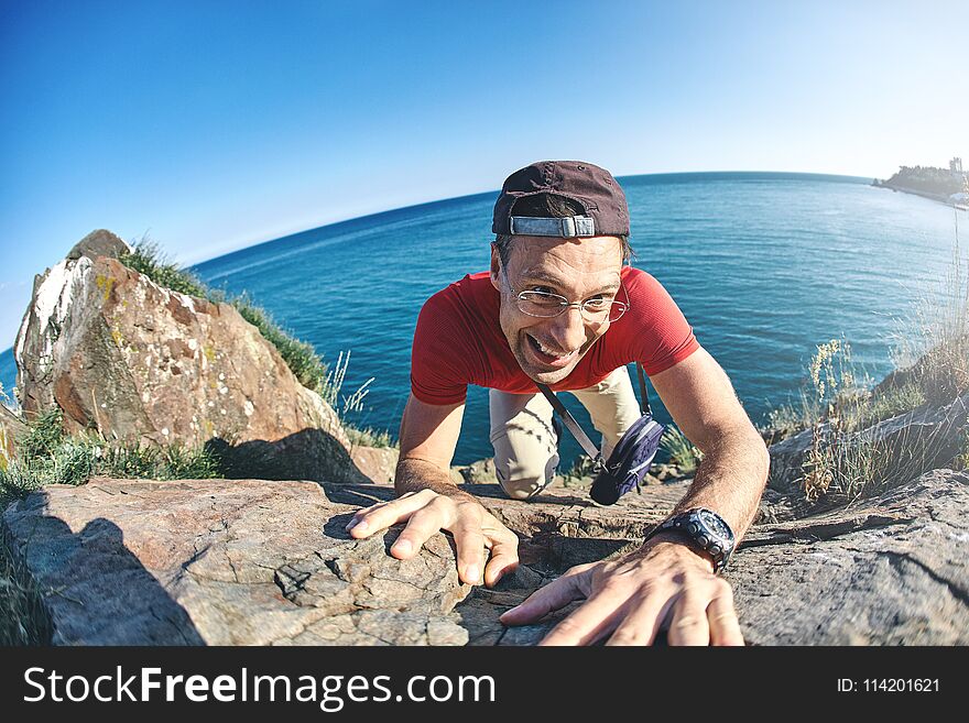 Man shows a heavy climbing on a rock