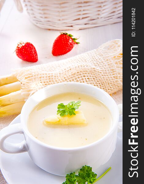 A asparagus cream soup with capers and fresh baguette
