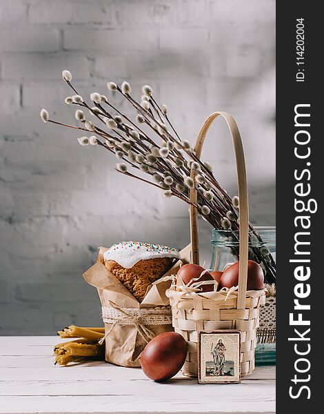 Easter bread, orthodox icon and painted eggs on wooden table