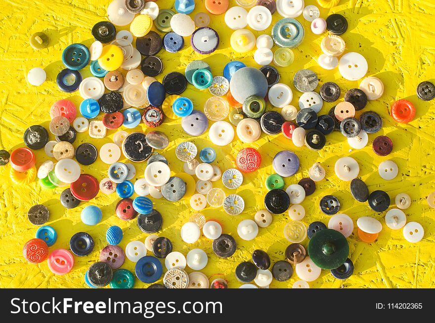 A set of buttons on a yellow background. needlework, hobby, creative, antiques