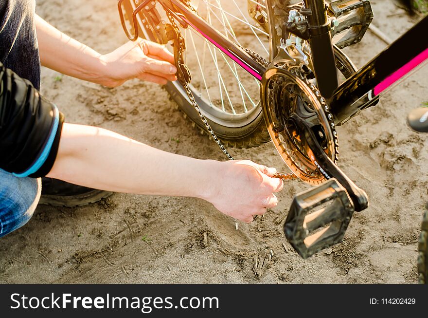 The guy repairs the bicycle. chain repair. cyclist. unratitude on the road, travel, close-up.