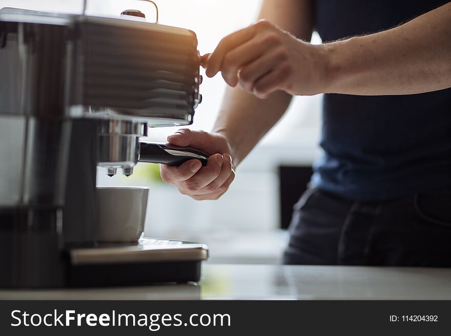 A man in the office prepares espresso for a coffee maker. A man in the office prepares espresso for a coffee maker