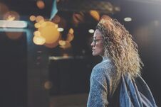 Pretty Woman In Stylish Clothing Wearing Eye Glasses Traveling In The European Night City. Bokeh And Flares Effect On Royalty Free Stock Image