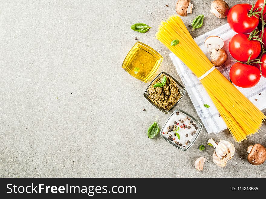 Food background, ingredients for cooking dinner. Pasta spaghetti, vegetables, sauces and spices, grey stone background copy space top view. Food background, ingredients for cooking dinner. Pasta spaghetti, vegetables, sauces and spices, grey stone background copy space top view