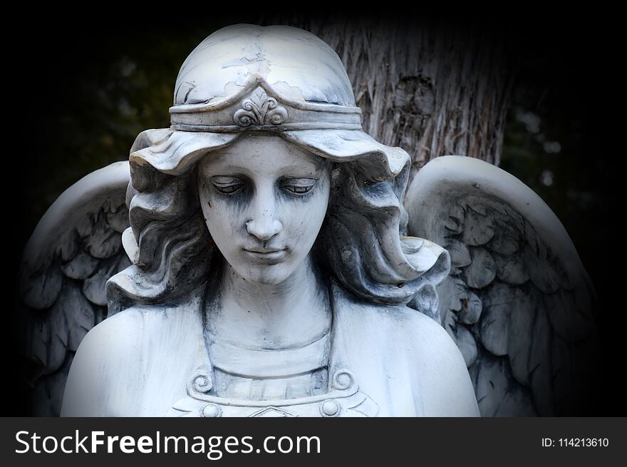 A beautiful Angel watching over God`s creation set in a stone statue. A beautiful Angel watching over God`s creation set in a stone statue.