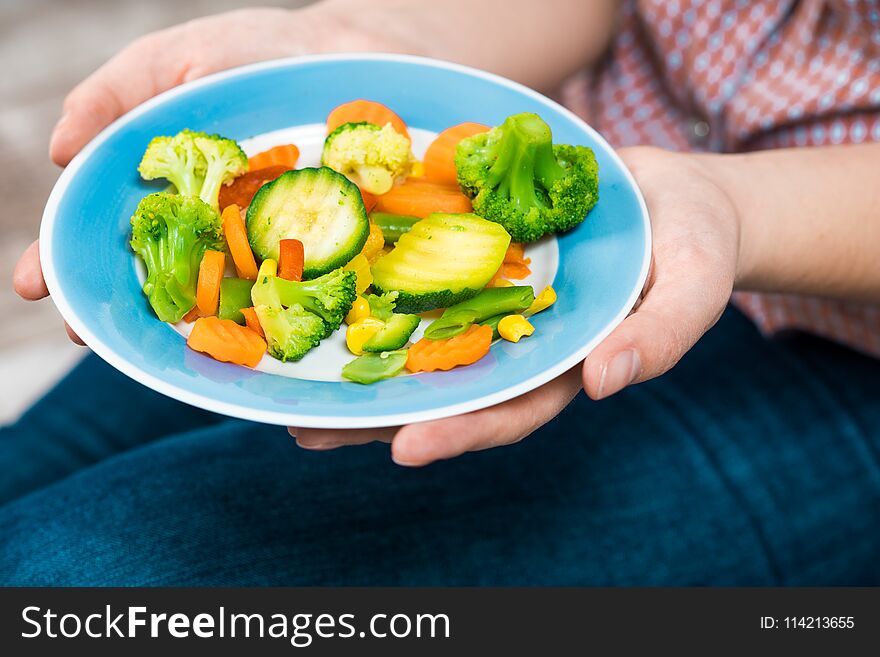 Girl With A Plate Of Vegetables In Hands