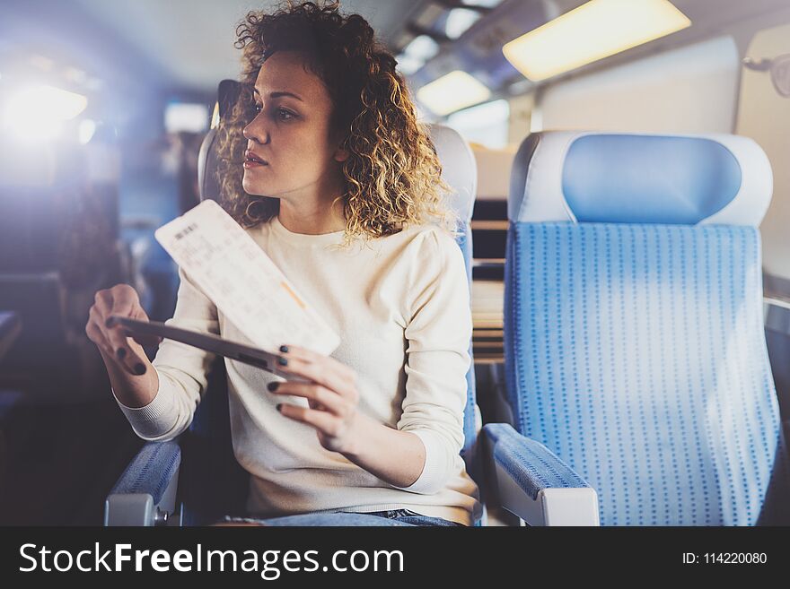 Enjoying business travel concept. Young beautiful brunette tourist girl travelling on the train sitting near the window
