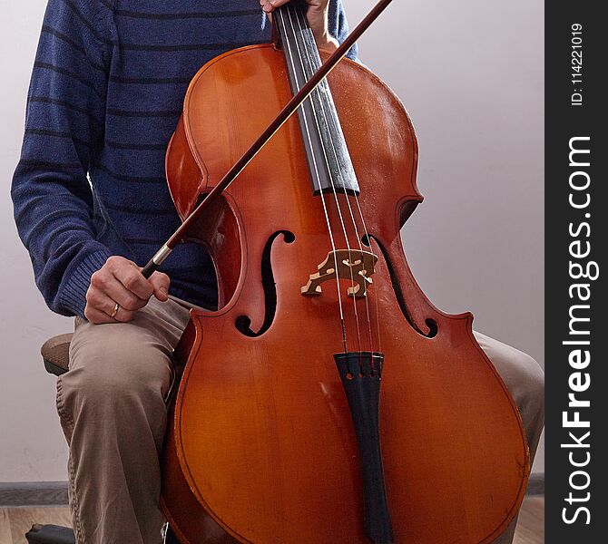 Man With Cello In Room With Wall