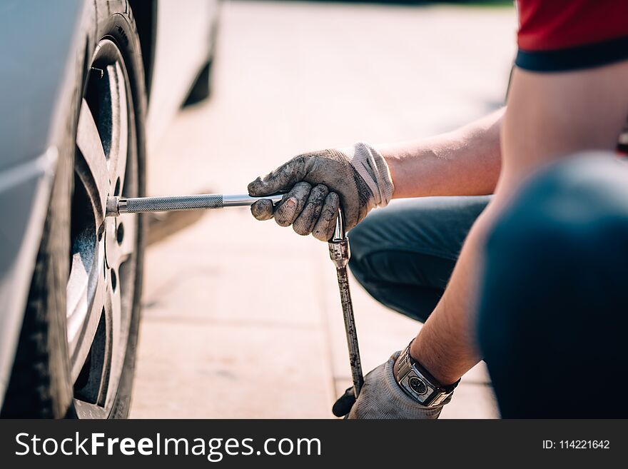 Close up details of mechanic changing tires, working in workshop and making repairs on automobiles