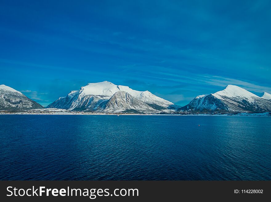 Outdoor view of beautiful mountain partial covered with snow, the in Hurtigruten region in Norway