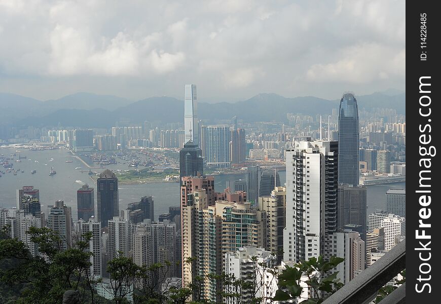 View of Hong Kong and its bay with ships and skyscrappers from a hill. View of Hong Kong and its bay with ships and skyscrappers from a hill