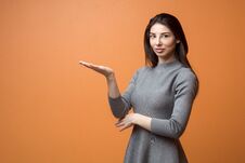 Portrait Of A Young Beautiful Business Woman In Neutral Dress Holding Out Empty Hand And Looking Into Camera Royalty Free Stock Photos Portrait Of A Young Beautiful Business Woman In Neutral Dress Holding Out Empty Hand And Looking Into Camera Royalty Free Stock Photos