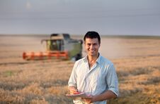 Engineer With Notebook And Combine Harvester In Field Stock Photography