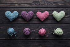 Colorful Crocheted Hearts & Skeins On Gray Wood Table Stock Image
