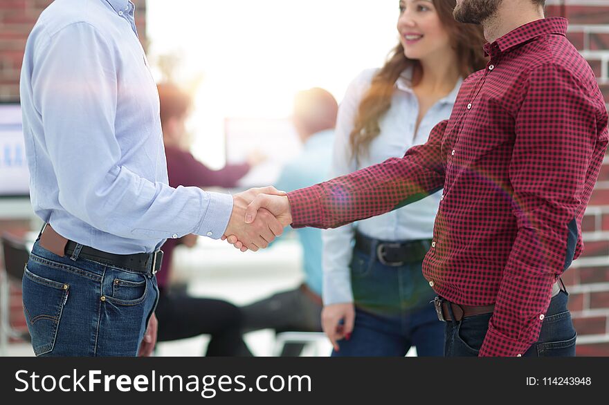 Handshake between businesspeople in a modern office. Handshake between businesspeople in a modern office.