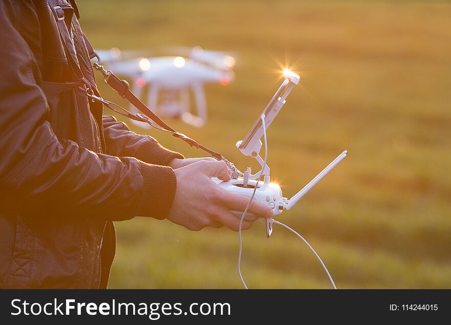 Farmer Navigating Drone Above Farmland