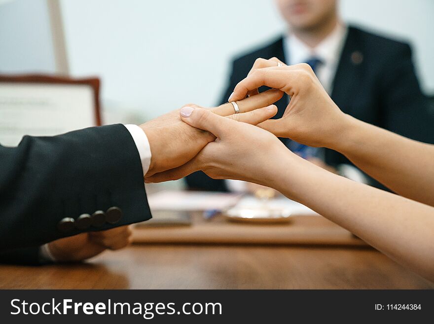 Woman Puts A Wedding Ring In A Registry Office For A Man. Marriage And Hands Close-up Against The Background Of The Ceremony Maste