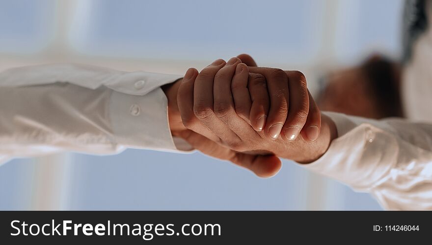 Closeup of a business handshake, on bright background. Closeup of a business handshake, on bright background