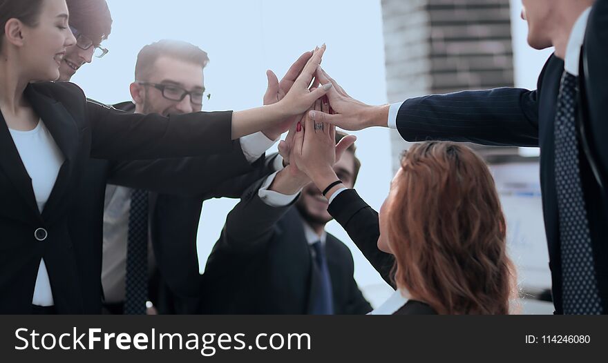 Triumphant business team giving each other high five. Triumphant business team giving each other high five