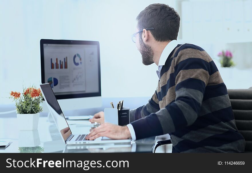 Businessman working with financial charts, sitting at his work Desk