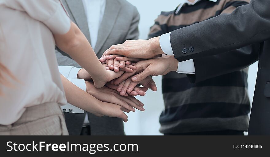 Teamwork concept.Business team standing joining hands together in the office.